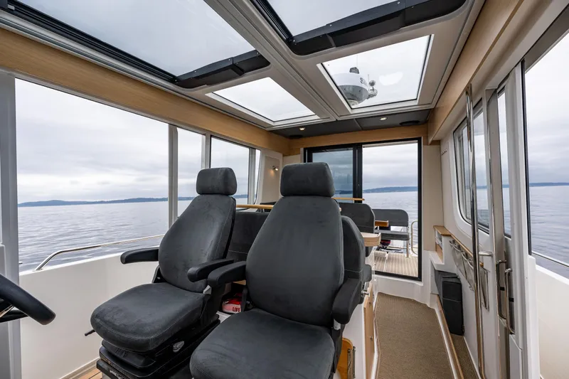 #41 Trade In Yacht Photos Pics Interior of 2022 Nimbus C11 boat with panoramic windows and comfortable seating.