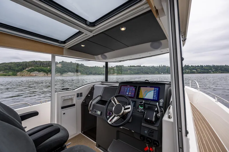 #41 Trade In Yacht Photos Pics Interior of 2022 Nimbus C11 boat with modern dashboard and scenic water view.