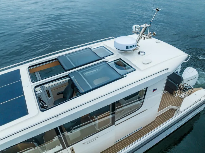 #41 Trade In Yacht Photos Pics 2022 Nimbus C11 boat with solar panels and sleek design on calm water.