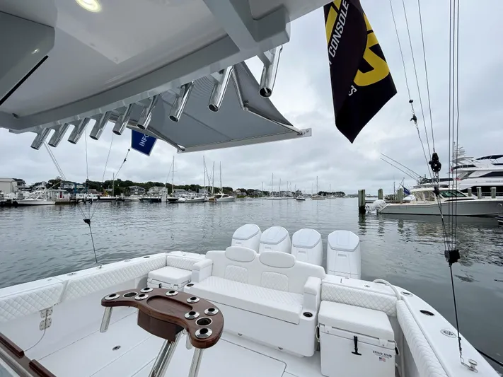  Yacht Photos Pics 2025 HCB 48 Campeon boat interior at marina, featuring seating and fishing rod holders.