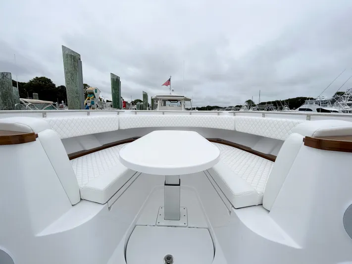  Yacht Photos Pics 2025 HCB 48 Campeon boat interior with white seating and table, docked at marina.