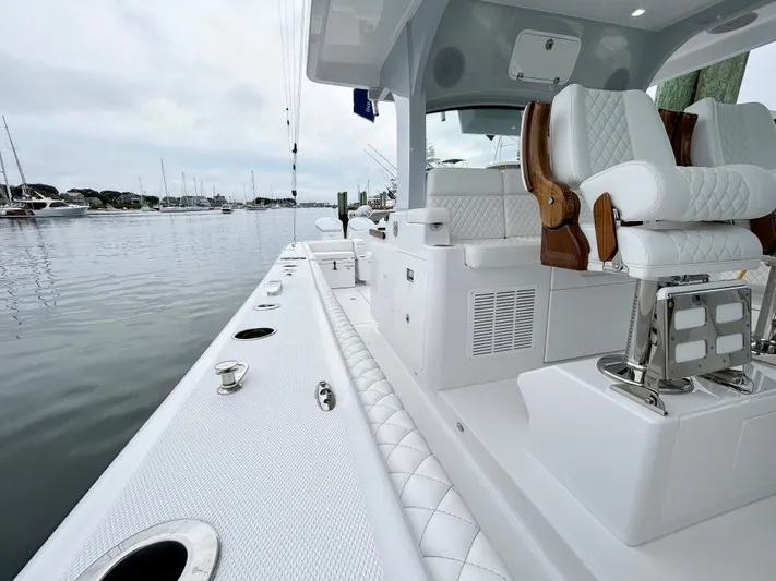  Yacht Photos Pics 2025 HCB 48 Campeon luxury boat with plush seating, docked in a serene marina.