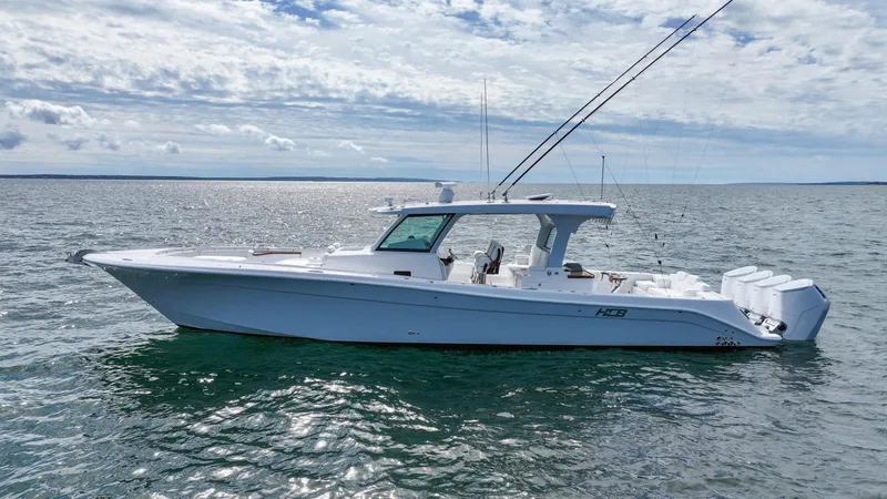  Yacht Photos Pics 2025 HCB 48 Campeon boat on calm water under cloudy sky.