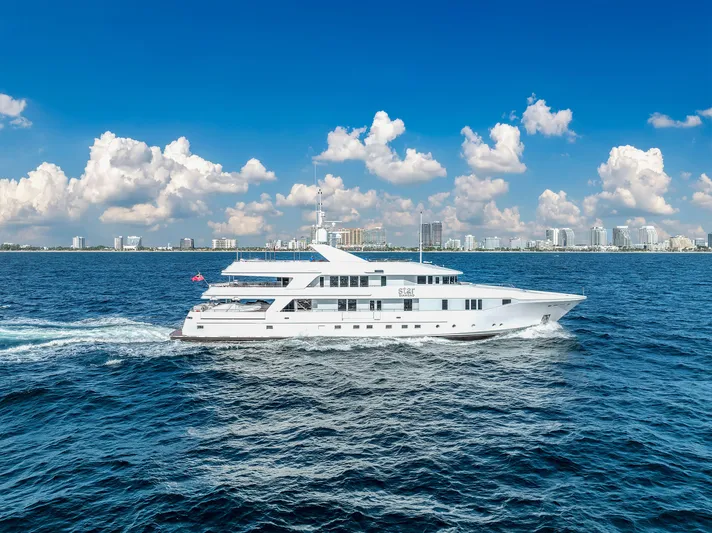 Star Diamond Yacht Photos Pics Luxurious 1998 Admiral Pilothouse yacht cruising on blue ocean with city skyline backdrop.