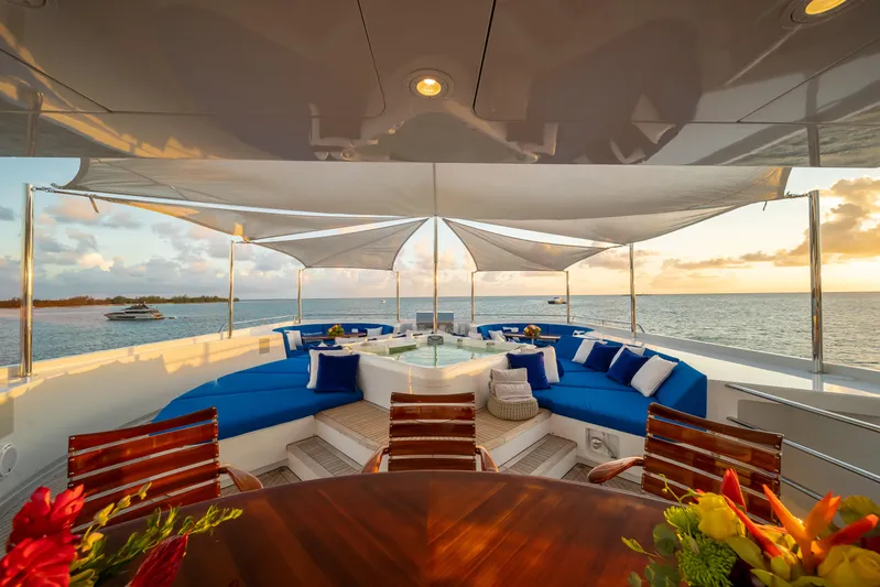 Star Diamond Yacht Photos Pics Luxurious 1998 Admiral Pilothouse yacht deck with blue seating, ocean view, and sunset ambiance.