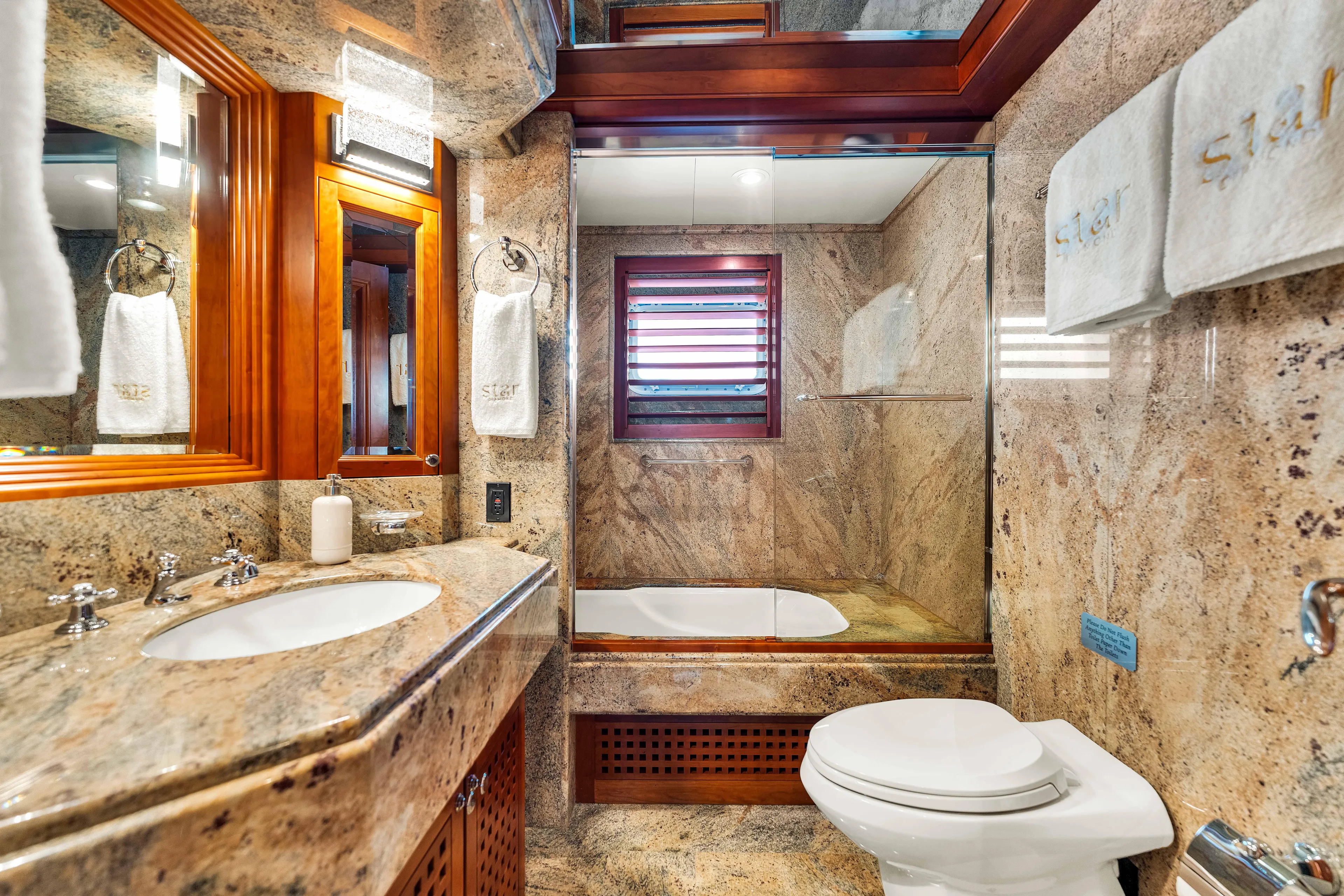 Star Diamond Yacht Photos Pics Luxurious 1998 Admiral Pilothouse yacht bathroom with marble finishes and elegant wood accents.