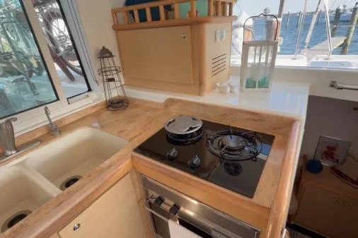 Apres Sea Yacht Photos Pics Compact kitchen in 2008 Lagoon 420 yacht with stove, sink, and window view.