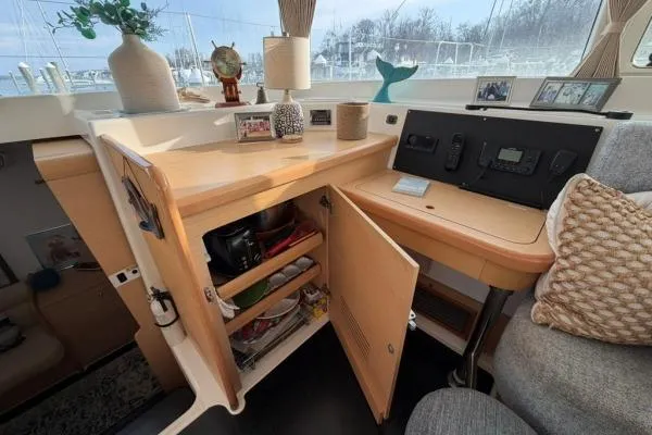 Apres Sea Yacht Photos Pics Interior of a 2008 Lagoon 420 yacht with open cabinet and navigation equipment.