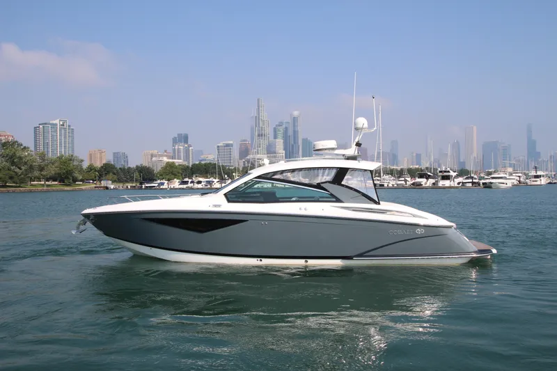  Yacht Photos Pics 2018 Cobalt A36 boat cruising on water with city skyline in background.