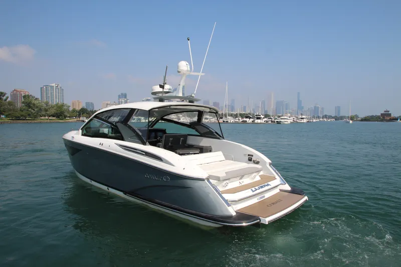  Yacht Photos Pics 2018 Cobalt A36 boat cruising on a scenic waterfront with city skyline.