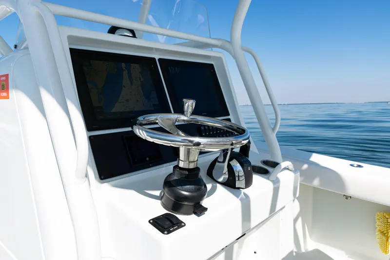  Yacht Photos Pics Steering console of 2014 Yellowfin 36 Offshore boat with navigation screens, on calm water.