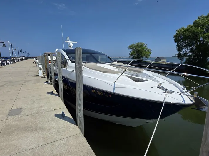  Yacht Photos Pics 2019 Sunseeker Predator 50 yacht docked at a marina under a clear blue sky.