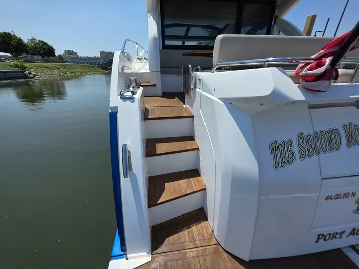  Yacht Photos Pics 2019 Sunseeker Predator 50 yacht stern with wooden steps and water view.