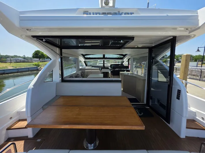  Yacht Photos Pics 2019 Sunseeker Predator 50 yacht interior with wooden table and open sliding doors.