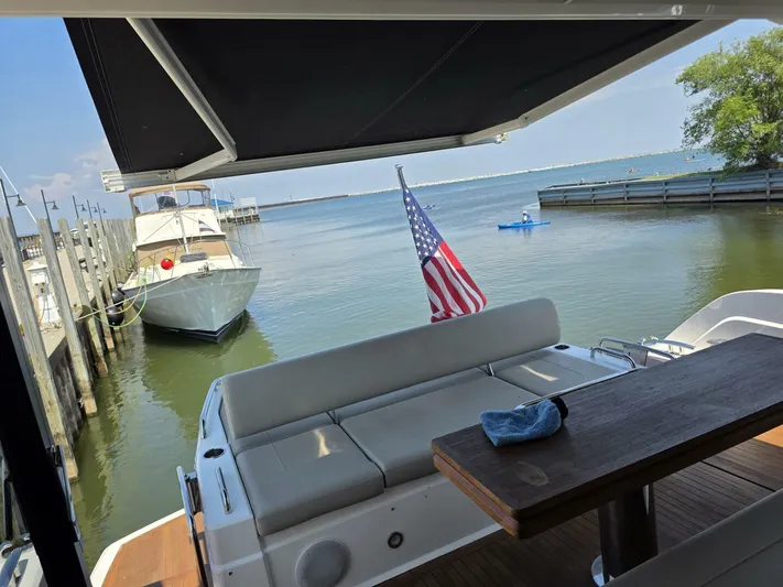  Yacht Photos Pics 2019 Sunseeker Predator 50 yacht with American flag, docked by calm waters.