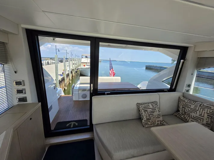  Yacht Photos Pics Interior view of 2019 Sunseeker Predator 50 yacht with dockside and ocean scenery.