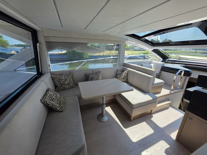  Yacht Photos Pics Luxurious interior of 2019 Sunseeker Predator 50 yacht with elegant seating and panoramic windows.