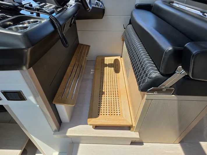  Yacht Photos Pics Interior helm seating of 2019 Sunseeker Predator 50 yacht with black leather and wood accents.