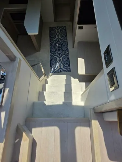  Yacht Photos Pics Interior stairs of 2019 Sunseeker Predator 50 yacht with elegant design and blue rug.