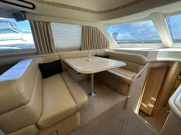 Anna Yacht Photos Pics Interior of 2001 Sea Ray 560 Sedan Bridge with beige leather seating and dining table.