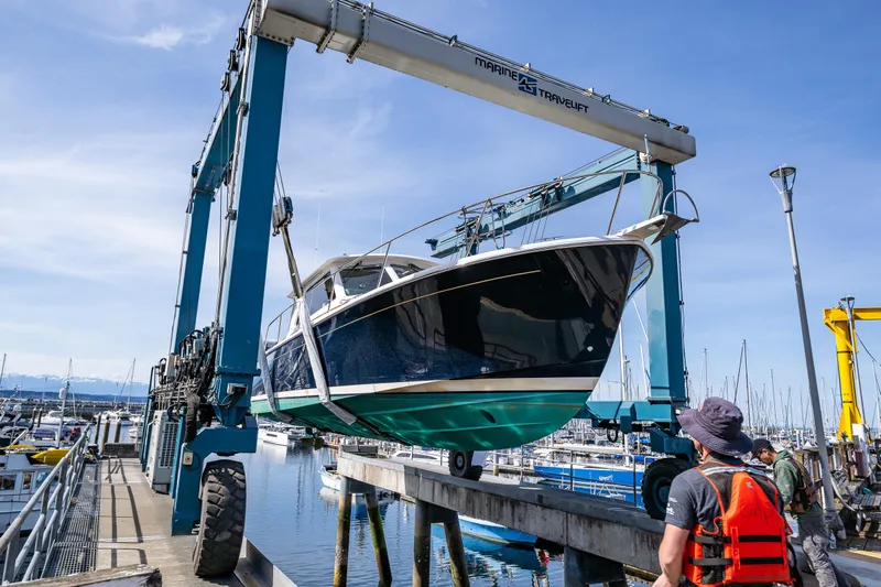 Tangled Up In Blue Yacht Photos Pics 2013 Back Cove 37 boat being lifted at a marina with a travel lift.