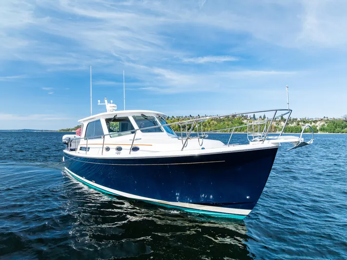 Tangled Up In Blue Yacht Photos Pics 2013 Back Cove 37 boat cruising on a sunny day, blue water and sky backdrop.