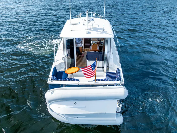 Tangled Up In Blue Yacht Photos Pics 2013 Back Cove 37 boat on water, rear view with American flag.