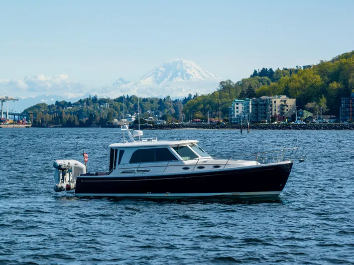 Tangled Up In Blue Yacht Photos Pics 2013 Back Cove 37 yacht on scenic water with mountain and city backdrop.