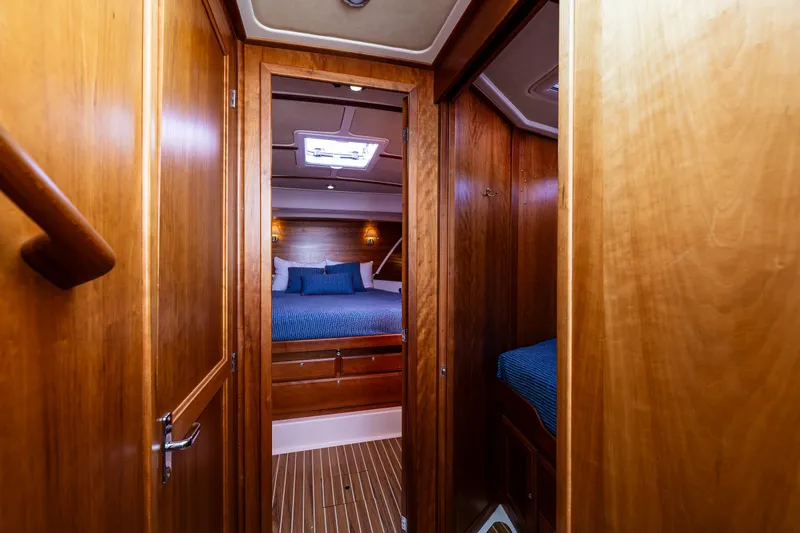 Tangled Up In Blue Yacht Photos Pics Interior of 2013 Back Cove 37 yacht, featuring cozy wooden cabin and blue bedding.