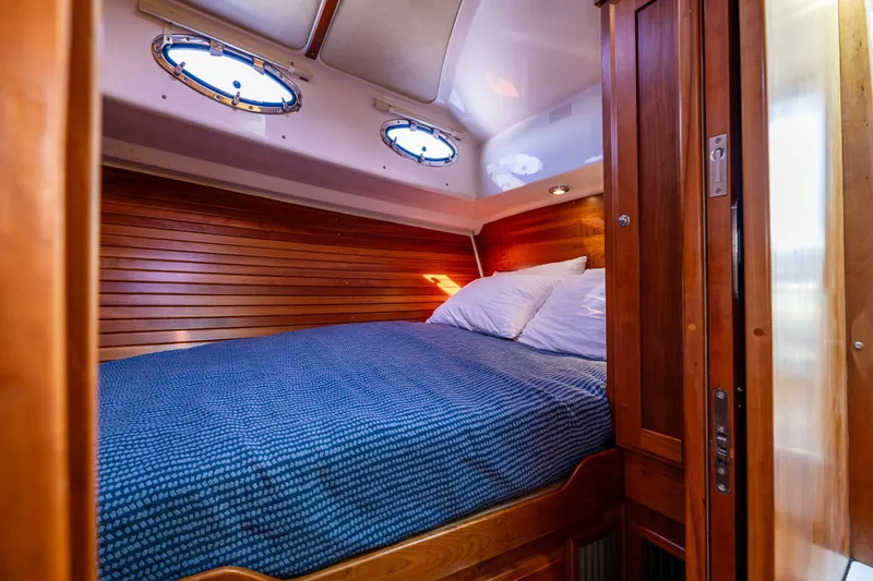 Tangled Up In Blue Yacht Photos Pics Cozy cabin interior of 2013 Back Cove 37 yacht with wooden paneling and blue bedding.