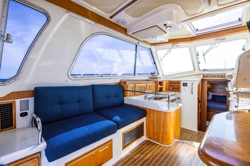Tangled Up In Blue Yacht Photos Pics Interior of a 2013 Back Cove 37 yacht with blue seating and wooden accents.
