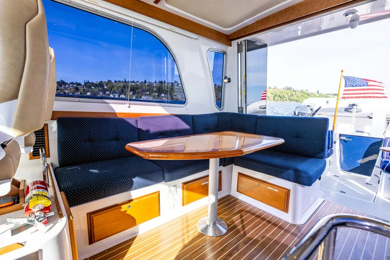 Tangled Up In Blue Yacht Photos Pics Interior of 2013 Back Cove 37 yacht with seating, table, and scenic window view.