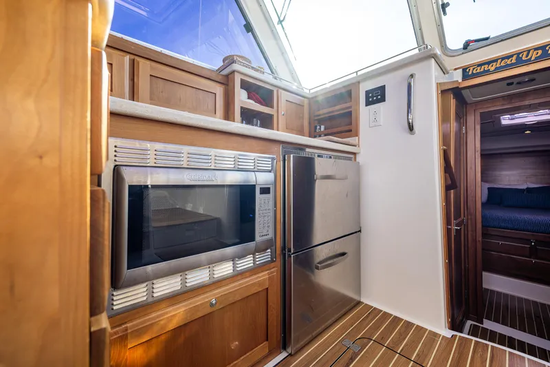 Tangled Up In Blue Yacht Photos Pics 2013 Back Cove 37 yacht kitchen with microwave, fridge, and wooden cabinetry.