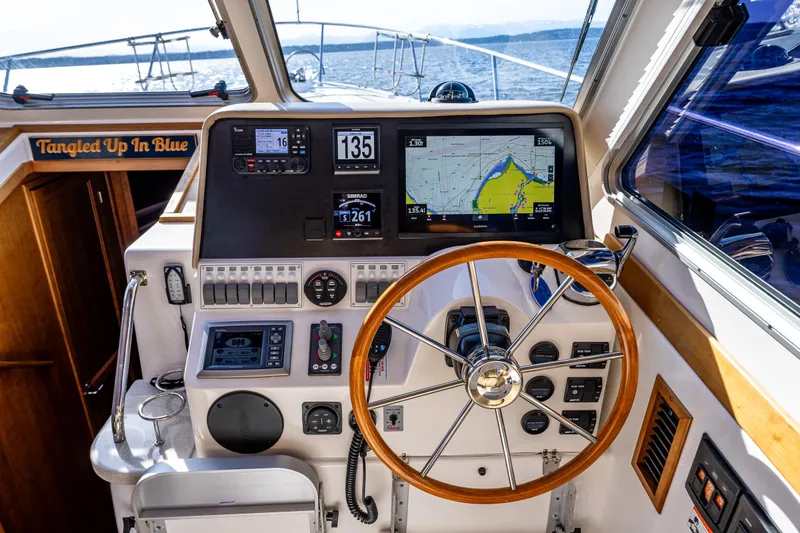 Tangled Up In Blue Yacht Photos Pics Helm of 2013 Back Cove 37 boat with navigation screens and wooden steering wheel.