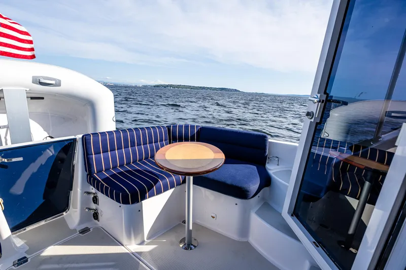 Tangled Up In Blue Yacht Photos Pics 2013 Back Cove 37 yacht with striped seating and table, overlooking the ocean.