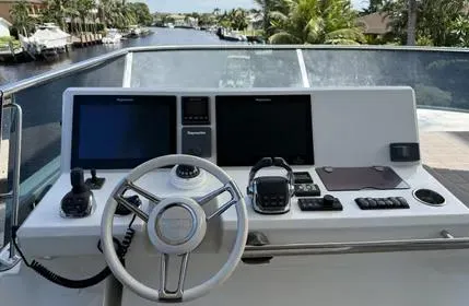  Yacht Photos Pics Control panel of a 2018 Prestige 680 yacht with navigation screens and steering wheel.