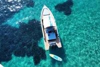 Aerial view of 2021 Scorpion 40 boat on clear turquoise water with paddleboard nearby.