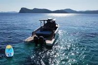 Scorpion 40 boat on sparkling sea with paddleboard, scenic island backdrop, 2021 model.