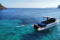 A 2021 Scorpion 40 boat anchored in clear blue waters with a paddleboard nearby.
