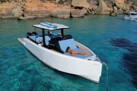 2021 Scorpion 40 boat anchored in clear turquoise water near rocky shoreline.