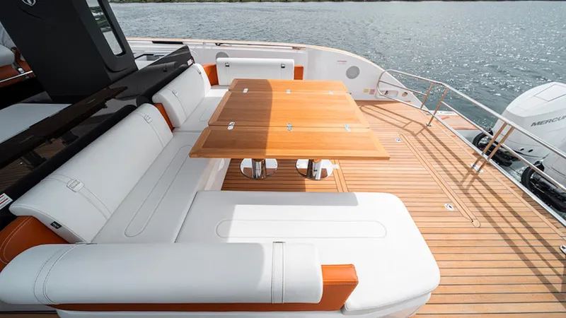  Yacht Photos Pics Luxurious seating area on 2025 Invictus TT 420S yacht with wooden table and white cushions.