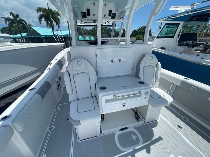 The Reel Commander Yacht Photos Pics 2026 Sea Fox 368 Commander interior with seating and storage, docked under clear skies.