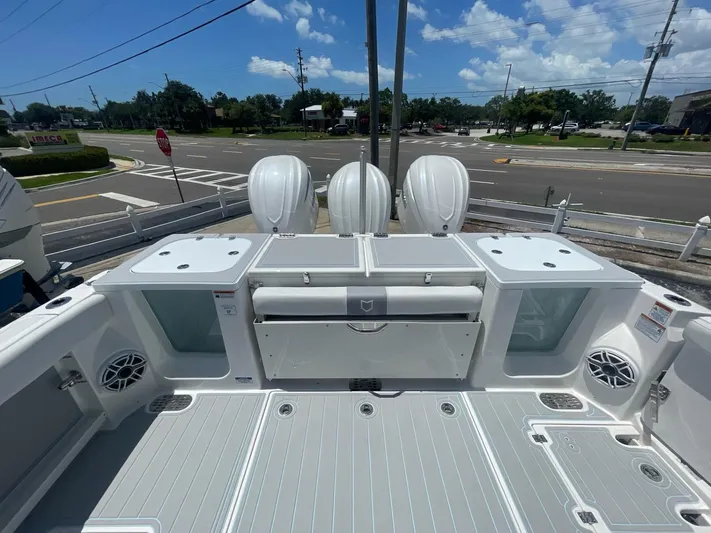 The Reel Commander Yacht Photos Pics 2026 Sea Fox 368 Commander boat deck with triple outboard engines, under a clear blue sky.