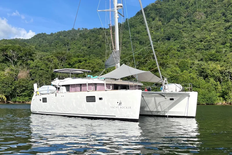  Yacht Photos Pics 2018 Lagoon 450 s catamaran anchored in scenic tropical waters with lush green hills.