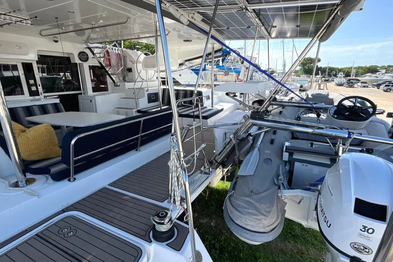  Yacht Photos Pics 2018 Lagoon 450 S catamaran with spacious deck, seating area, and outboard motor.