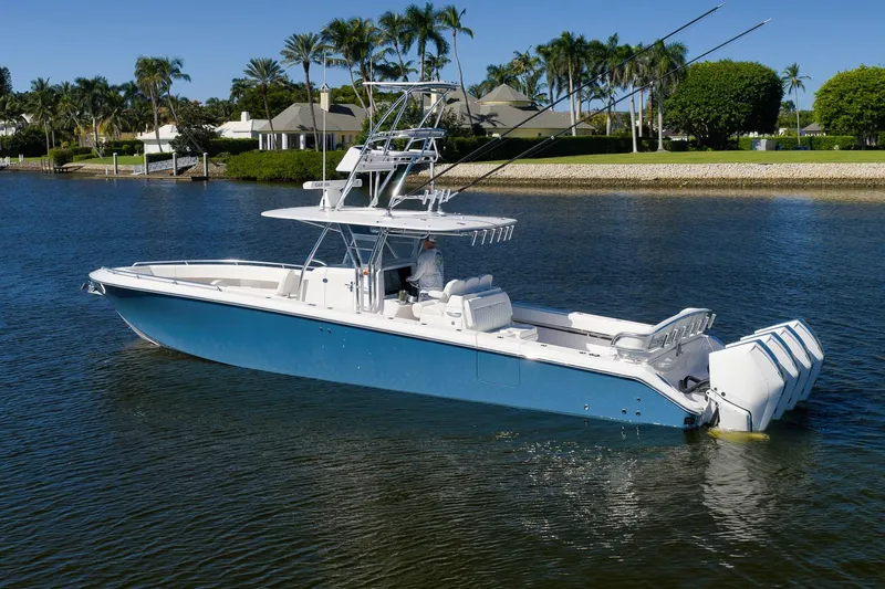  Yacht Photos Pics 2021 Bahama 41 boat on calm water, surrounded by lush greenery and luxury homes.