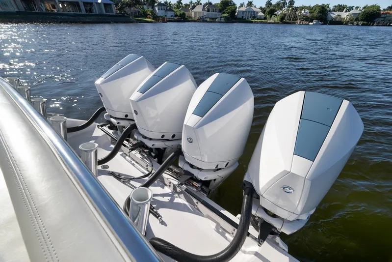  Yacht Photos Pics Four powerful outboard motors on a 2021 Bahama 41 boat, docked by the water.