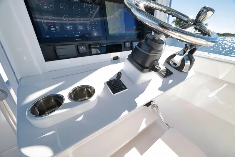  Yacht Photos Pics Control panel of a 2021 Bahama 41 boat with steering wheel and navigation screens.