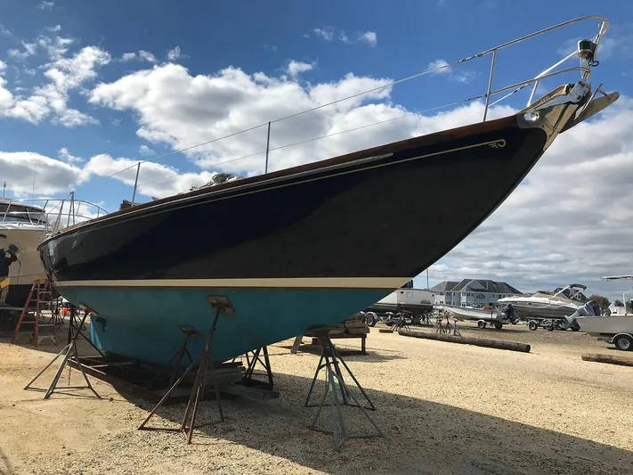 Perelandra Yacht Photos Pics 1968 Hinckley Bermuda 40 sailboat on stands, clear sky background.