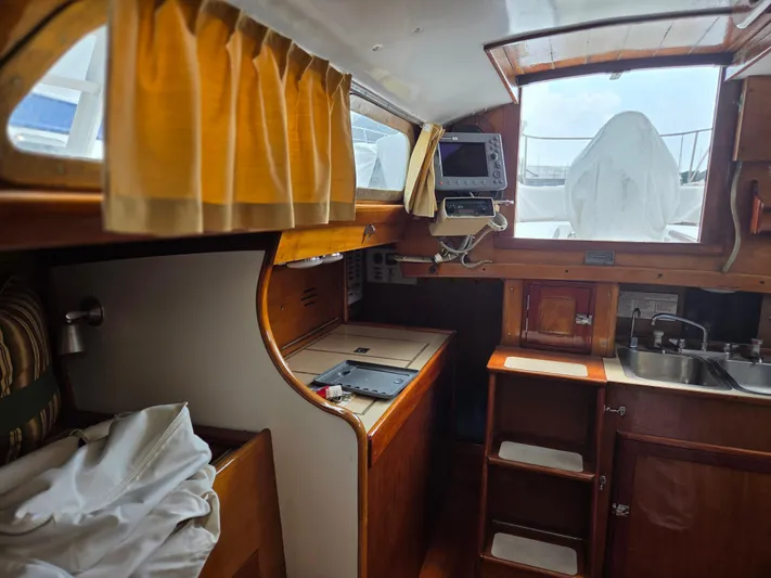 Perelandra Yacht Photos Pics Interior of a 1968 Hinckley Bermuda 40 sailboat with wooden cabinetry and nautical equipment.